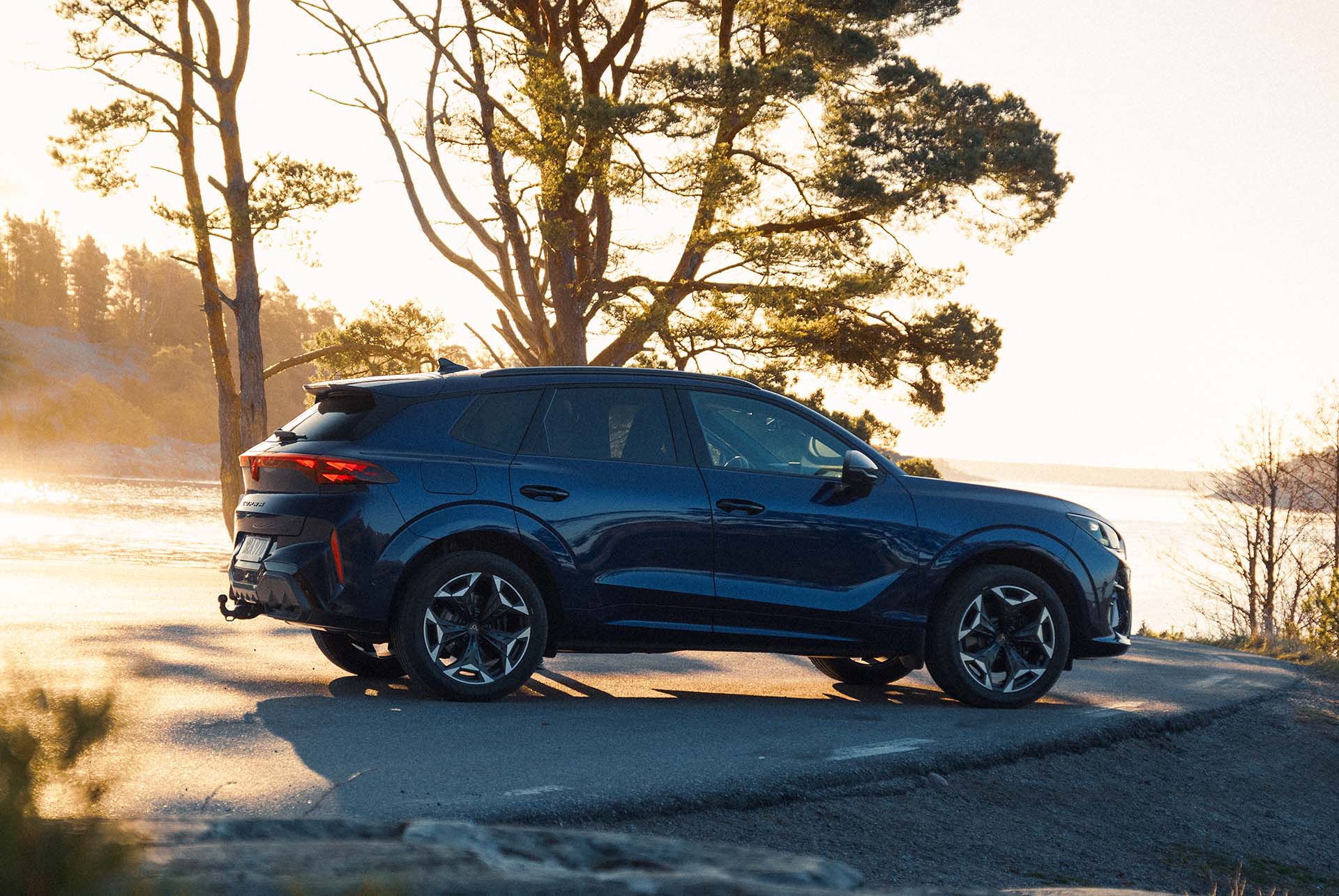 ny suv, laddhybridmodell cupra terramar 2024, med panoramasoltak, elegant design och moderna lättmetallfälgar, på våt asfalt vid havet. Fågelperspektiv.