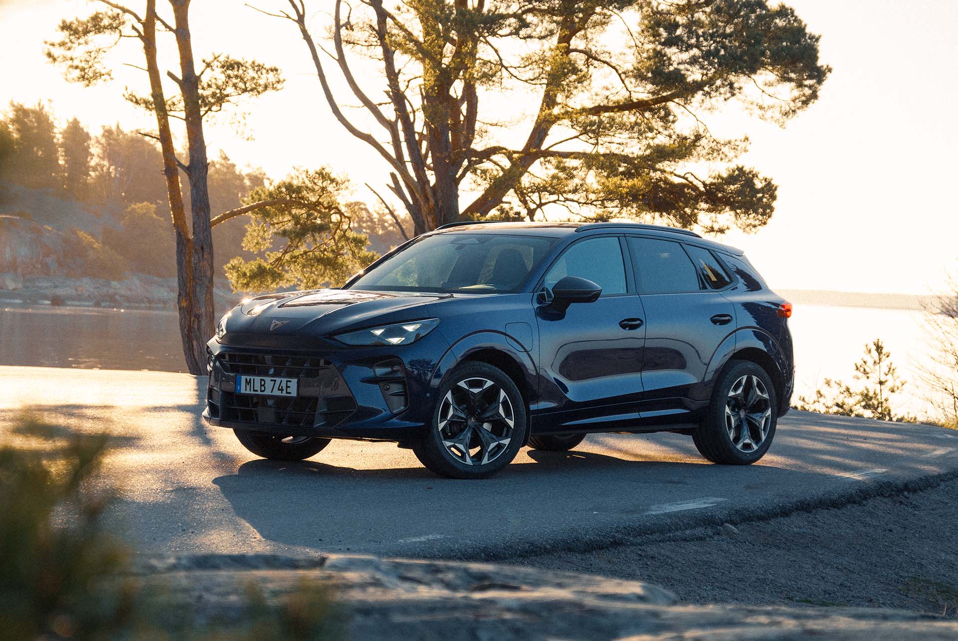 cupra terramar laddhybrid suv, ny 2024-modell, sett bakifrån, eleganta baklyktor med cupra-logotyp, moderna lättmetallfälgar och en sportig kaross, på våt väg vid havet. 