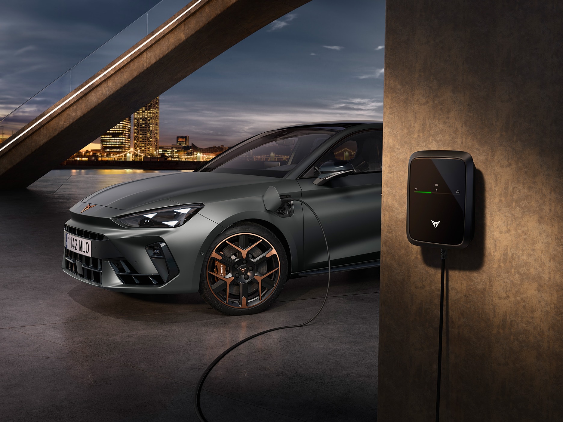 CUPRA Leon parkerad i en urban miljö på natten medan den laddas.