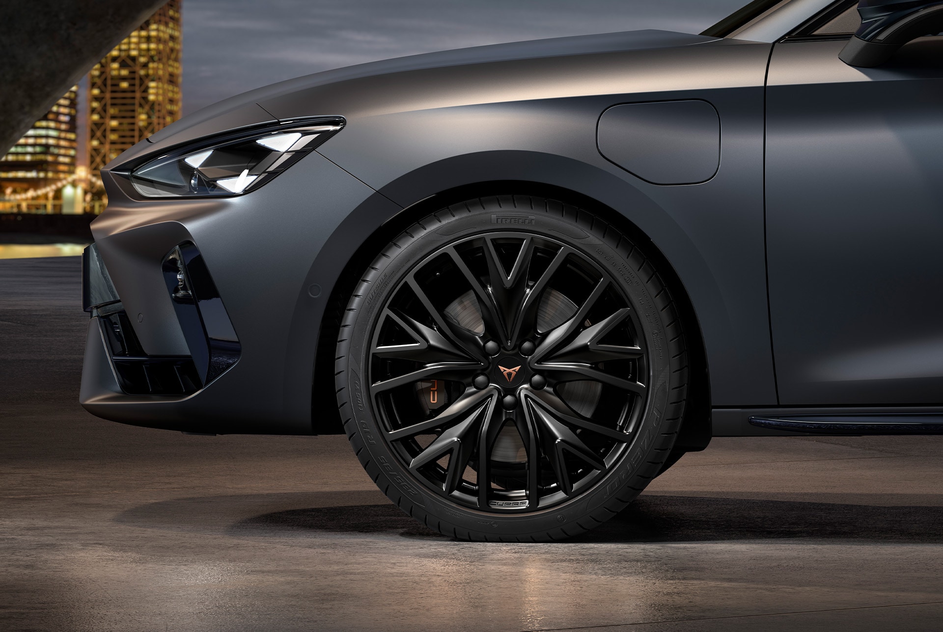 front side view of left alloy wheel in sport black matt for the new Cupra Leon Sportstourer 2025, tyres, signature headlights and grey body.