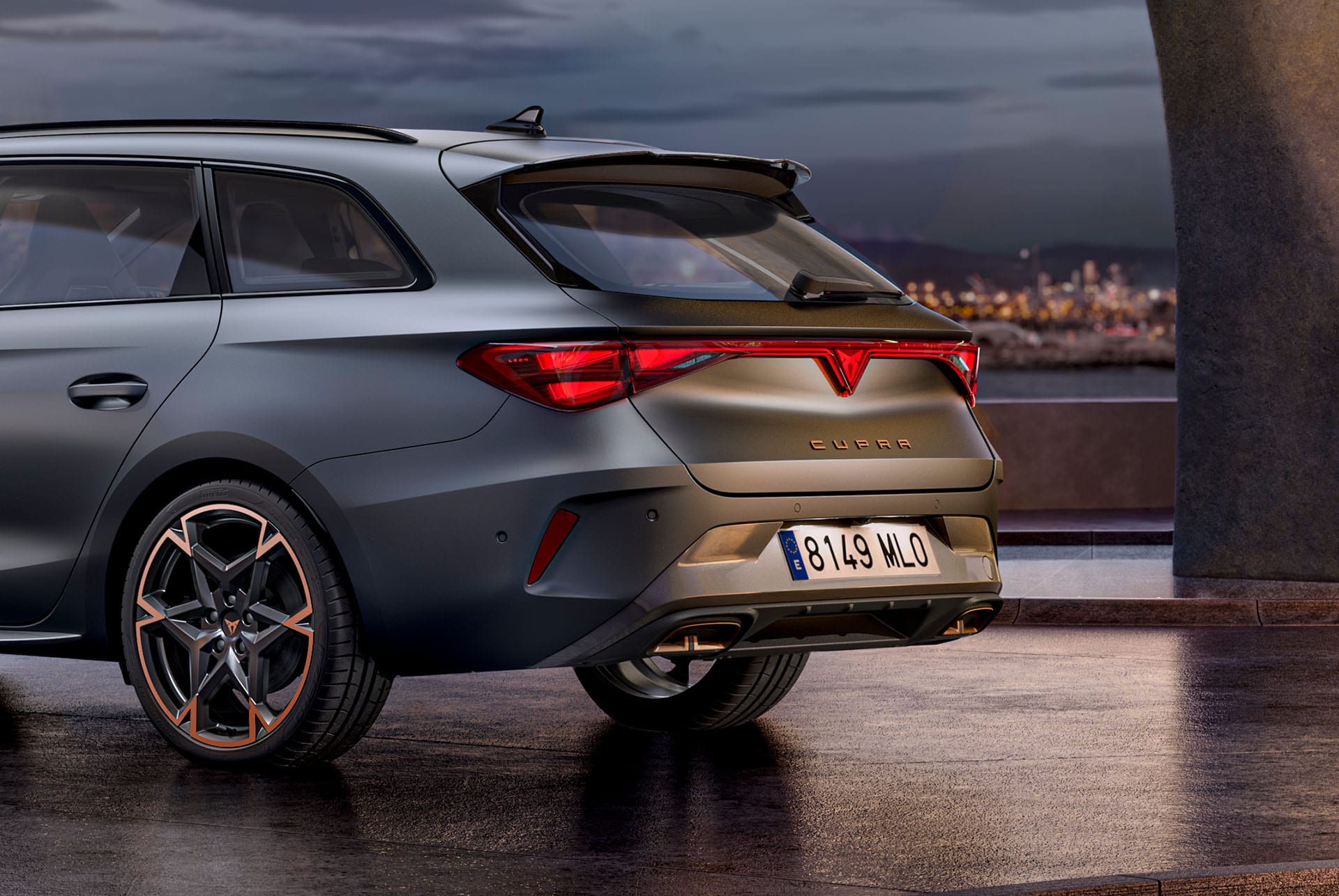 närbild bakifrån från sidan av den nya hybridbilen cupra leon enceladus grey matt 2024, smidda fälgar med kopparaccenter, betongstruktur och stadens skyline