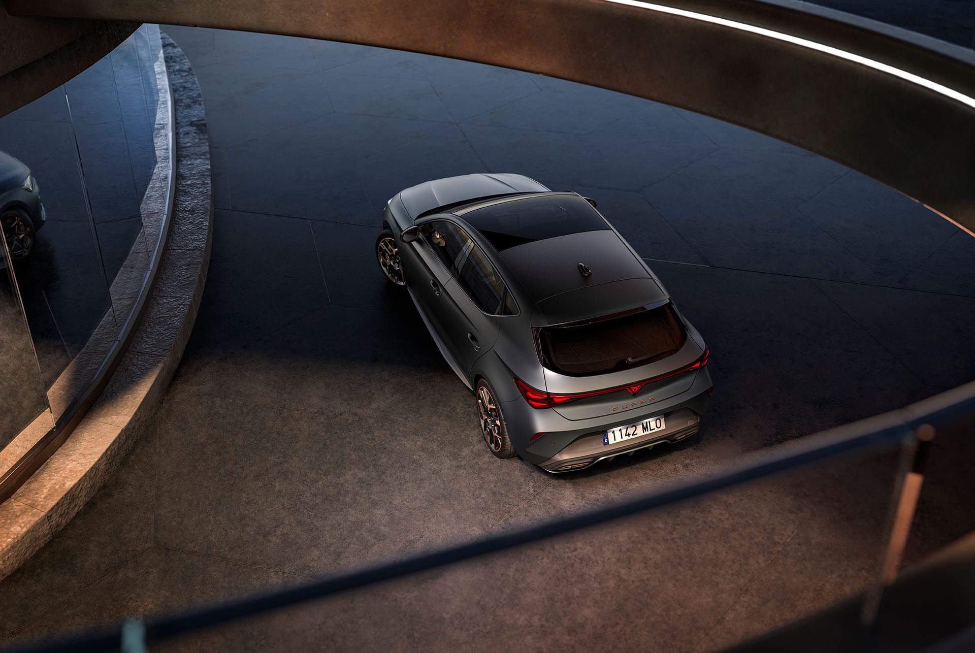 Nya cupra leon 2024 hybridbilsteknik, LED-bakljus, PHEV-bil parkerad på cement, struktur med glödande kanter. Bilen visas i matt grå lack med smidda kopparfälgar och svarta fälgar.