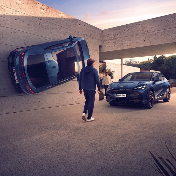 Surrealistisk arkitekturscen med en blå CUPRA-bil vertikalt monterad på en betongvägg bredvid en annan blå bil som normalt står parkerad på en uppfart, med en person som går mot ingången.