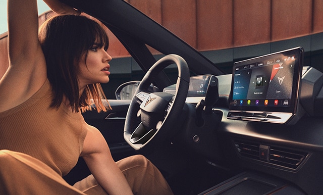 Woman viewing the CUPRA OTA updates on her car's infotainment device.