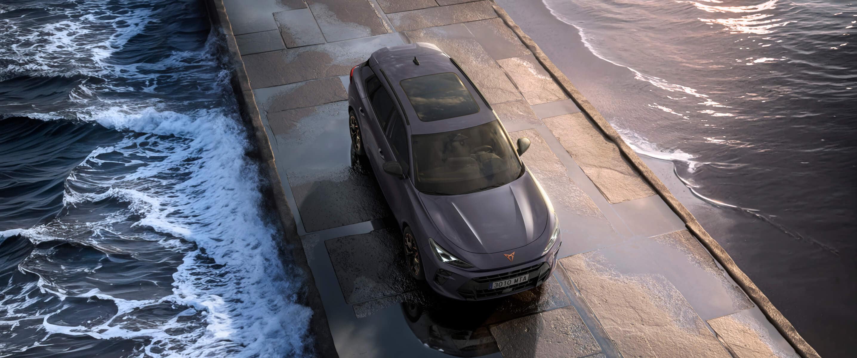CUPRA Terramar 2024 hybrid-SUV på en våt trottoar vid havet, med moderna lättmetallfälgar och hajnosformat frontparti