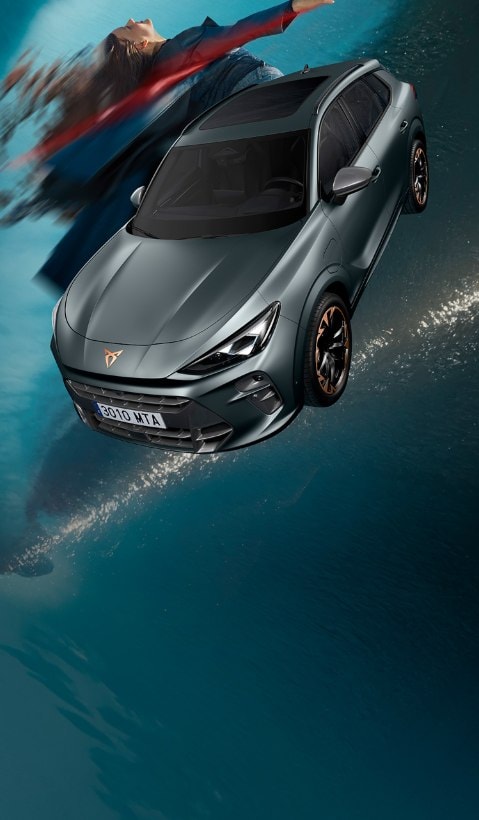 A CUPRA Terramar SUV shown from a high angle, appearing to be in motion with a red light streak extending from its side to a person lying horizontally in the air next to it.